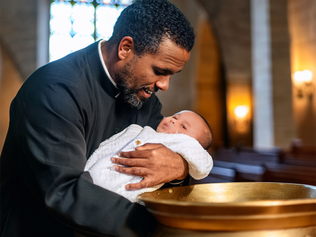 A baby being baptised at a font